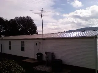 New metal roof on a single wide mobile home with a TV antenna in New Waverly